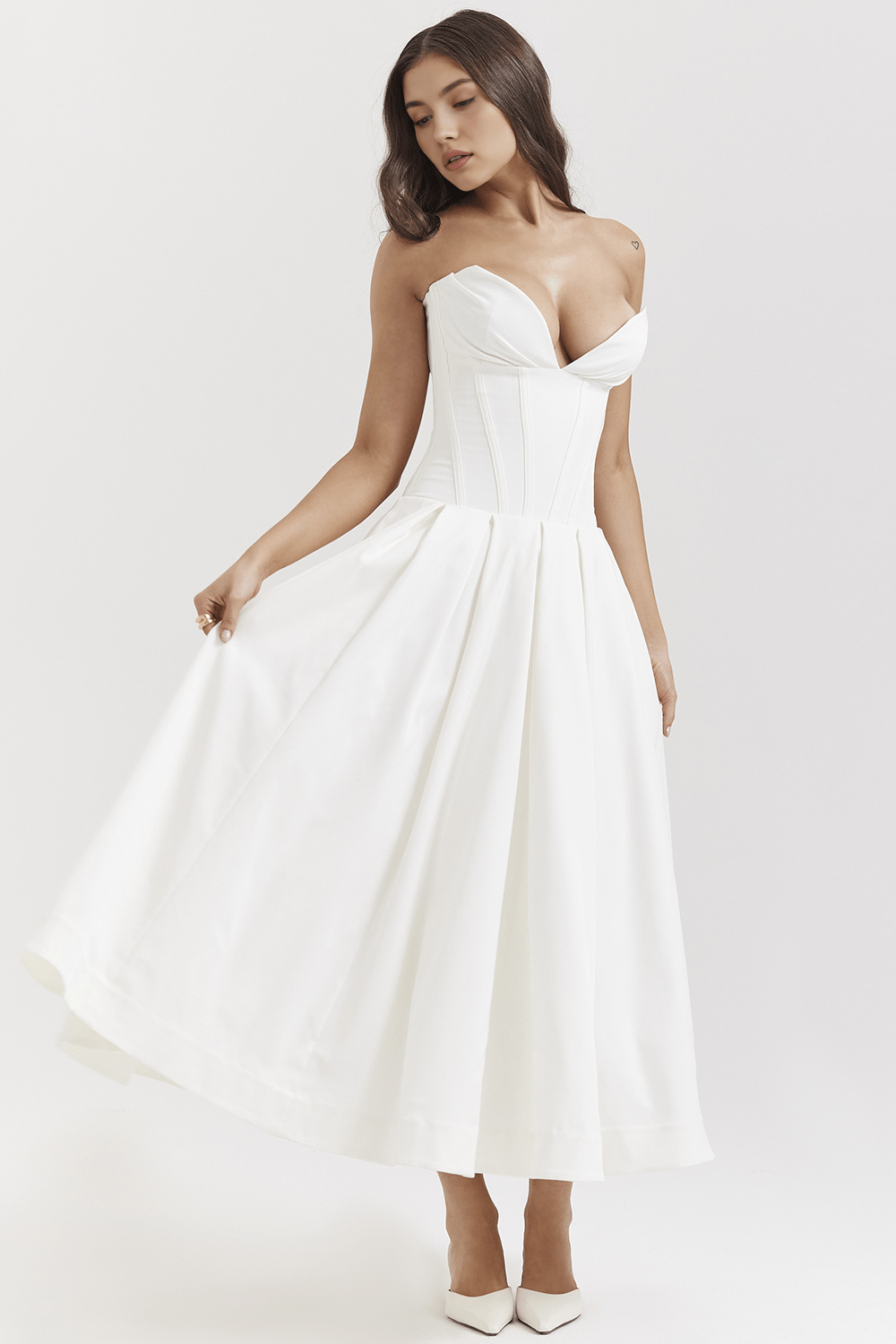 Robe moulante blanche, design minimaliste et élégant, parfaite pour une occasion spéciale.